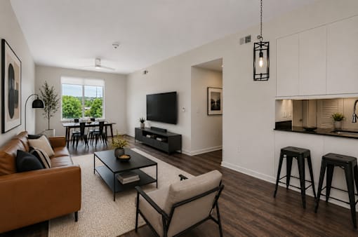 A living room with a brown couch, a black coffee table, and a flat screen TV.