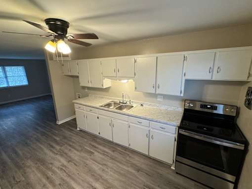 A kitchen with white cabinets and a black stove top oven.