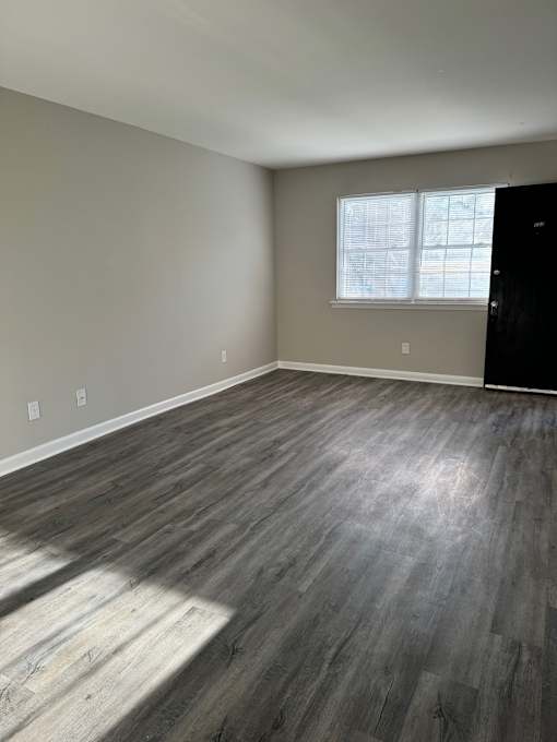 A room with a window and a grey floor.