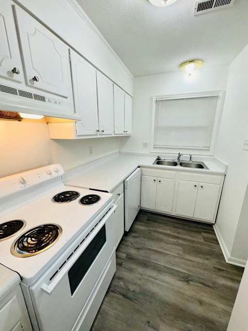 A white stove and cabinets in a kitchen.