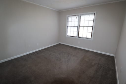 an empty room with carpet and a window