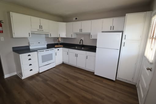 a kitchen with white cabinets and a white stove and refrigerator