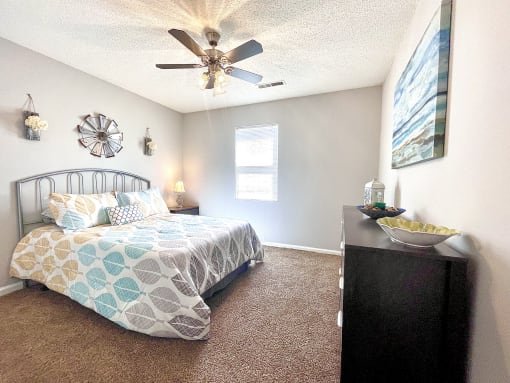 a bedroom with a bed and a ceiling fan