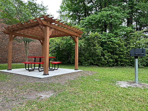 A wooden pergola with a picnic table underneath it.