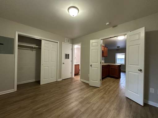 A room with white doors and wooden floors.