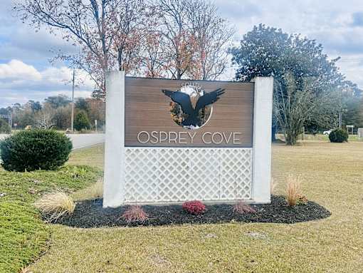 A sign that says "Osprey Cove" with a bird silhouette on it.
