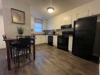 a kitchen with black appliances and a table and chairs