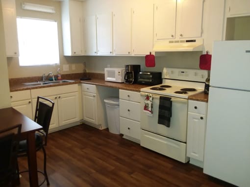 a kitchen with white appliances and white cabinets