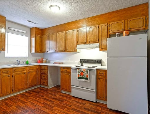 a kitchen with white appliances and wooden cabinets