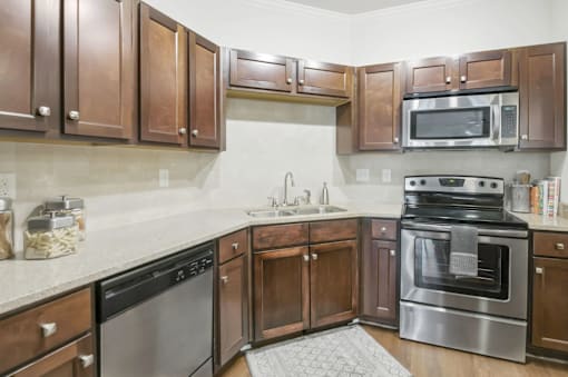 A kitchen with brown cabinets and stainless steel appliances.at Residence at Marina Bay, South Carolina