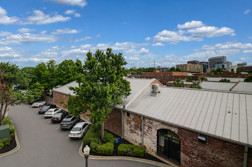 A parking lot with cars and a building with a metal roof.
