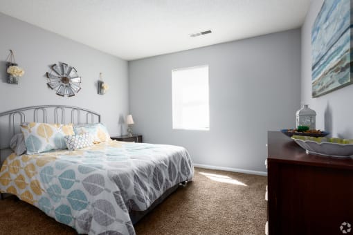 a bedroom with a bed and a dresser and a window