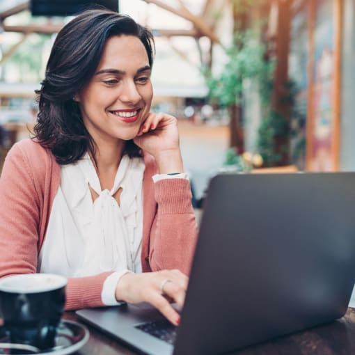 a woman sitting at a table using a laptop computer