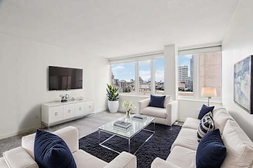 A living room with white furniture and a flat screen TV.