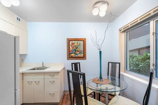 a kitchen and dining room with a glass table and chairs