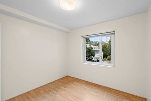 a room with white walls and a window and a wooden floor