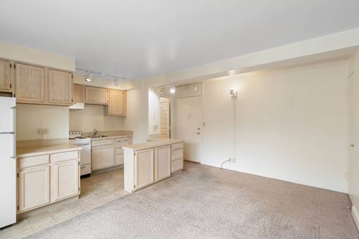 a kitchen with white cabinets and a sink and a refrigerator