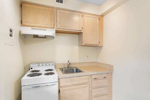 a kitchen with white appliances and wooden cabinets