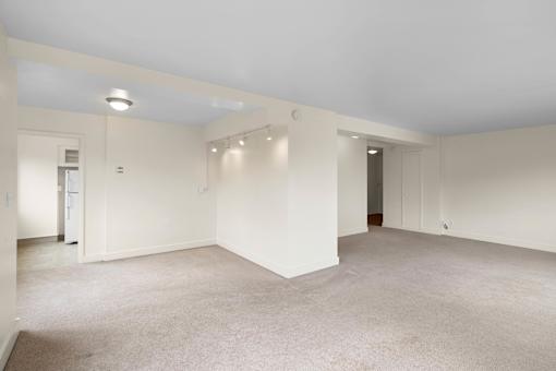 a living room with white walls and a carpet floor