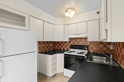 a kitchen with black counter tops and white appliances