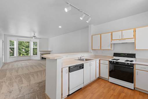 a kitchen with white cabinets and a stove and a sink at Oriel Apartments, Portland, 97225