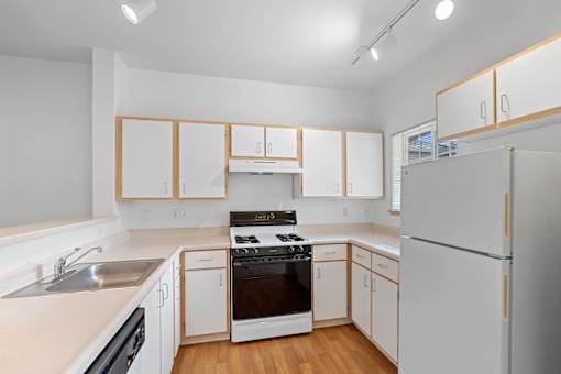 a kitchen with white cabinets and a stove and a refrigerator at Oriel Apartments, Portland, 97225