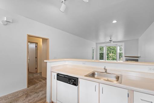 a kitchen with white cabinets and a sink and a window at Oriel Apartments, Portland, OR