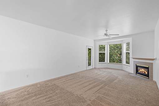 a living room with a ceiling fan and a fireplace at Oriel Apartments, Oregon, 97225