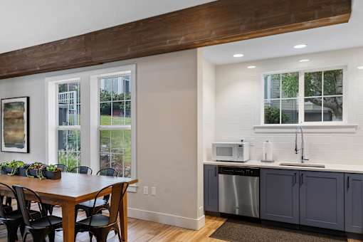 a kitchen with a table and a counter with two microwaves at Oriel Apartments, Portland, OR, 97225