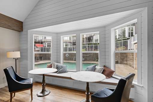 a screened in porch with tables and chairs and a pool at Oriel Apartments, Portland, Oregon