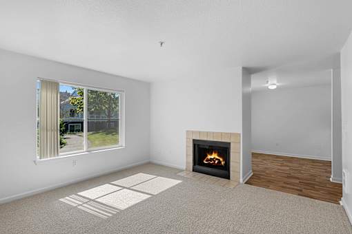 a living room with a fireplace and a window at Summer Creek Apartments, Tigard, OR