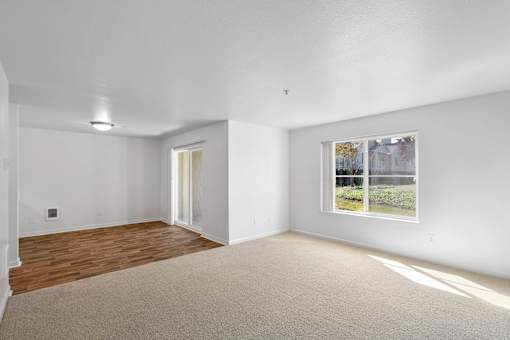 a living room with white walls and a window at Summer Creek Apartments, Oregon