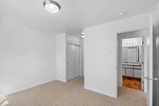 a bedroom with white walls and a door to a bathroom at Summer Creek Apartments, Oregon, 97223
