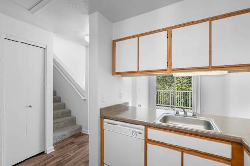 a kitchen with a sink and a window and a staircase at Summer Creek Apartments, Oregon, 97223