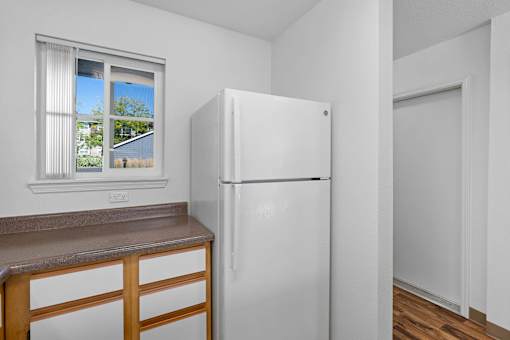 a kitchen with a refrigerator and a window at Summer Creek Apartments, Tigard, 97223