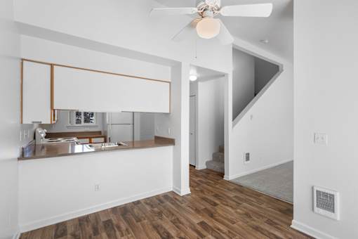 a living room with a kitchen and a ceiling fan at Summer Creek Apartments, Tigard