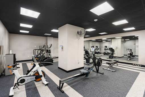 a gym with exercise equipment and weights in a building
