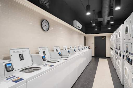 a laundry room with a counter and a clock on the wall