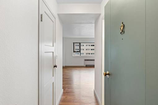 an empty room with a door open to a living room