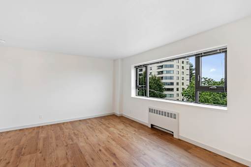 a living room with wood floors and a large window