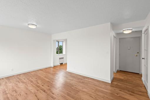 an empty living room with white walls and wood floors