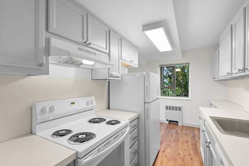 a white kitchen with white appliances and white cabinets