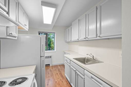 a white kitchen with white cabinets and white appliances