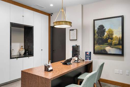 a office with a desk and a painting on the wall