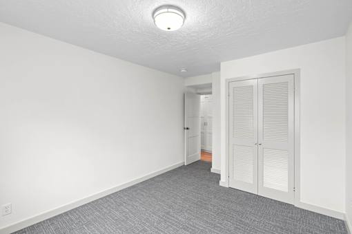 an empty room with white walls and a door to a bathroom