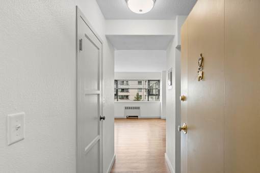 a view of a living room from a hallway with a door open