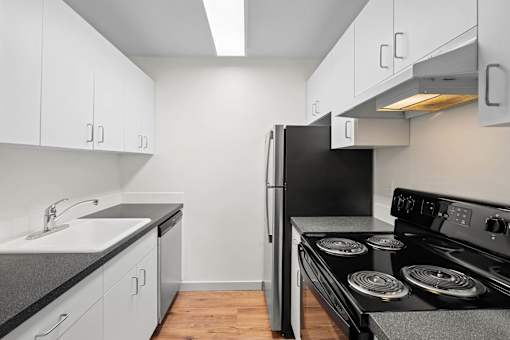 a kitchen with white cabinets and a black stove and refrigerator