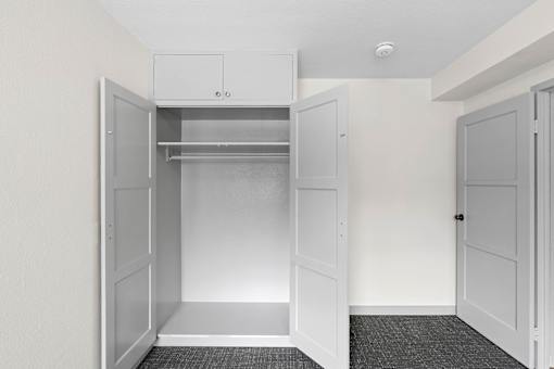an empty closet in a home with white walls and white doors
