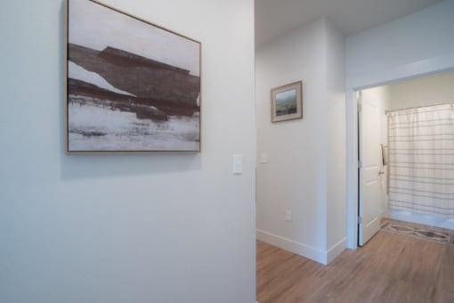 a painting hanging on a wall in a room with a door to a hallway at Sonder Fields in Happy Valley, OR