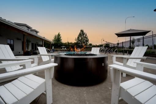a round fire pit with white chairs around it at Sonder Fields in Happy Valley, OR